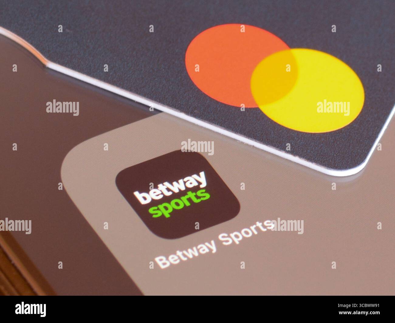 Betway Sports gambling app on smartphone screen with Mastercard debit card to deposit money Stock Photo