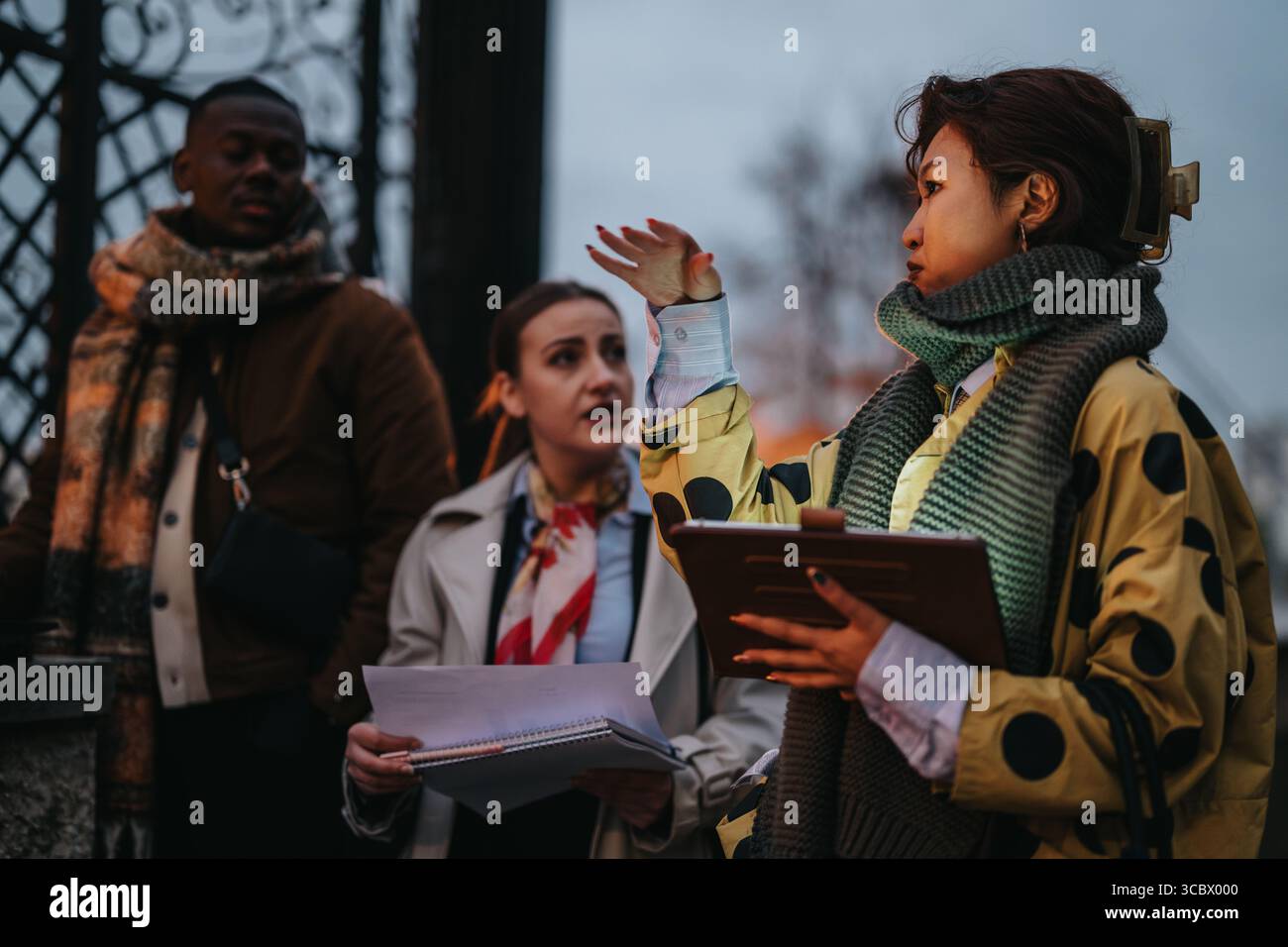 Multiracial people collaborating outdoors with documents Stock Photo