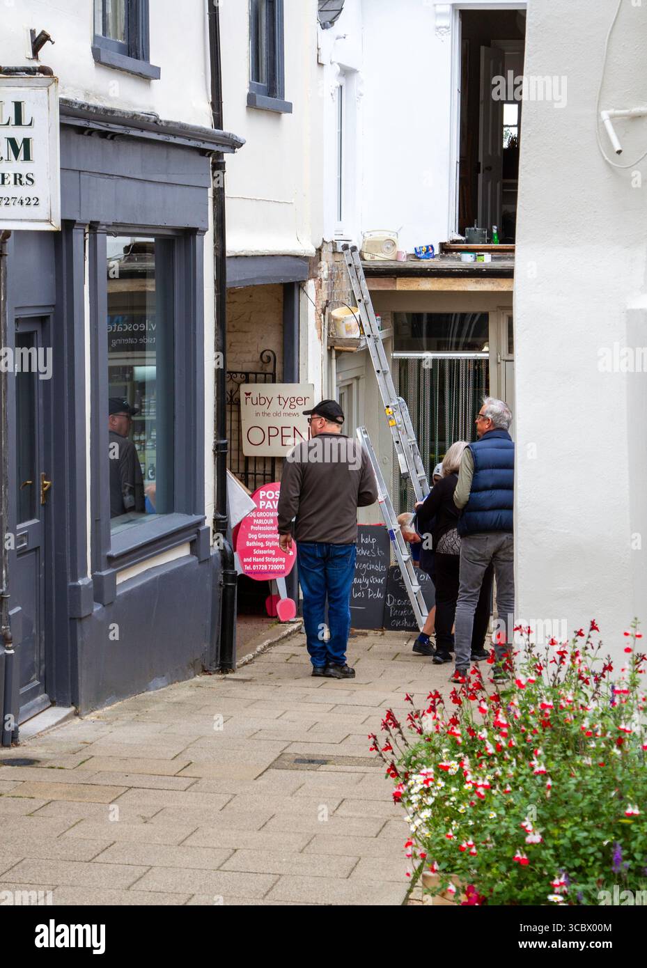 In Framlingham a Suffolk town on a busy summer's day for the Tuesday market in a corner there is slight disorder because of ongoing exterior painting Stock Photo