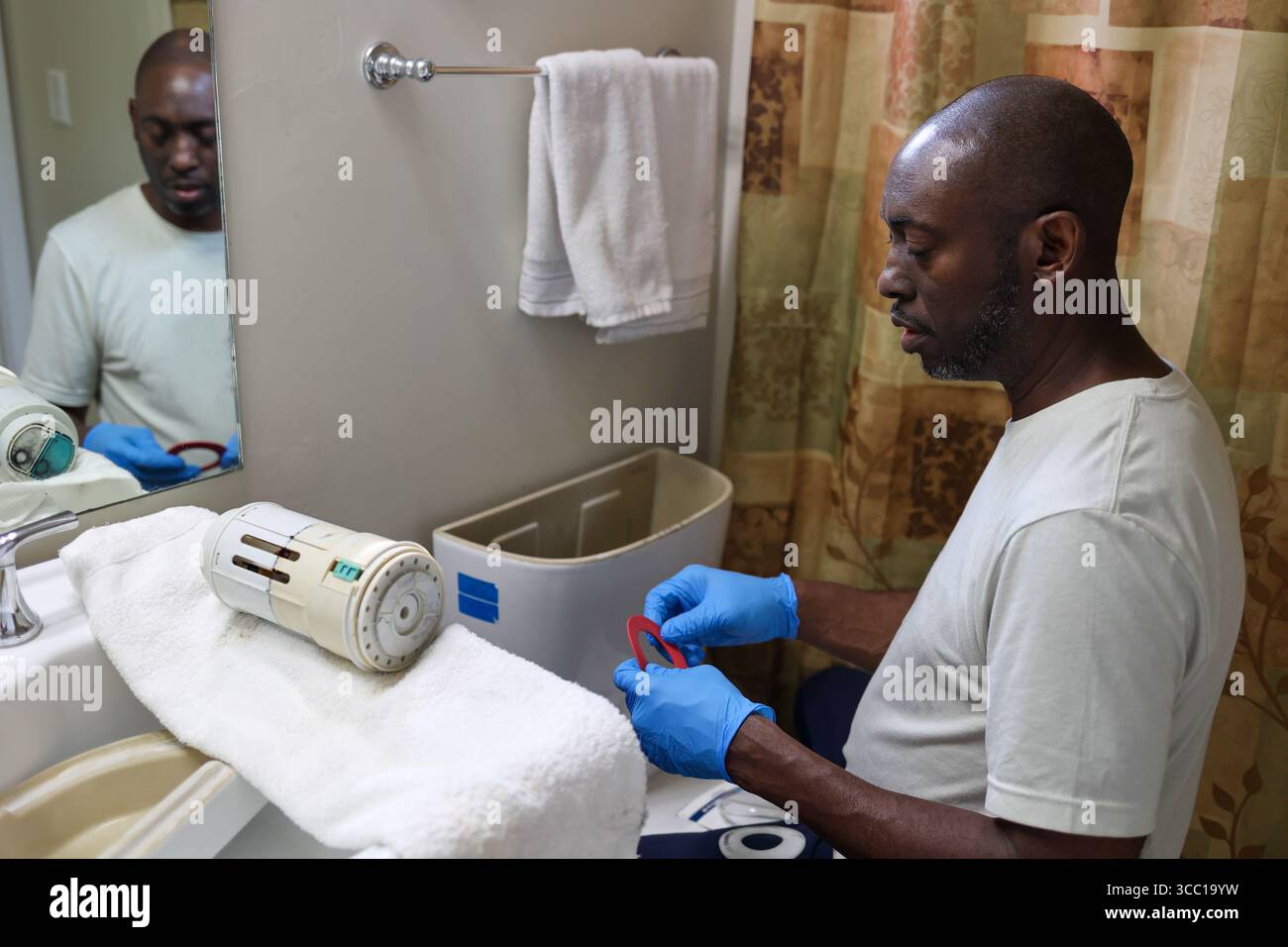 A portrait of a black repairing a broken toilet Stock Photo