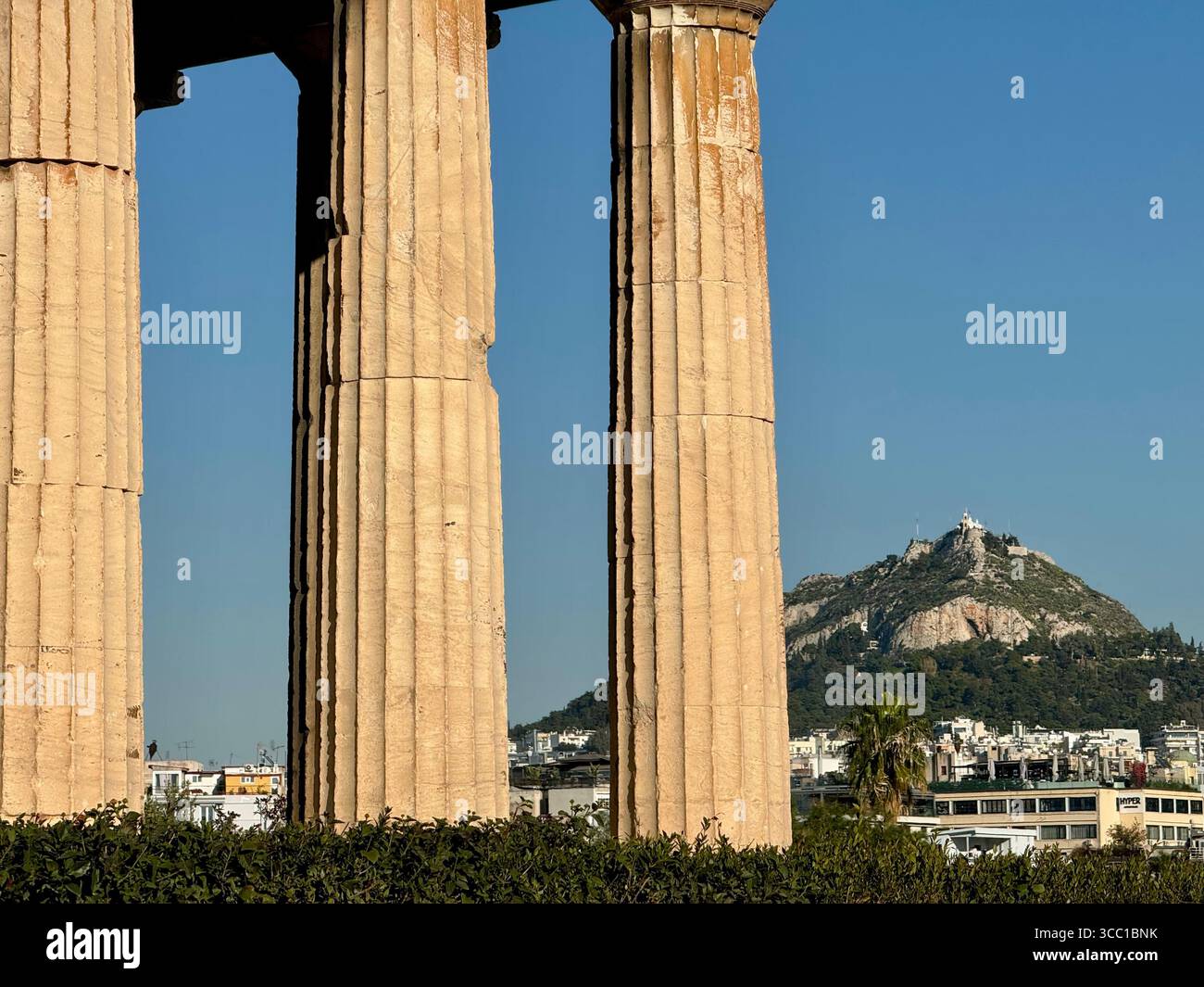 Viewpoint perspective of Temple of Hephaistos with Lycabettus Mountain in the background, Athens, Greece. - Smartphone Captured Stock Image