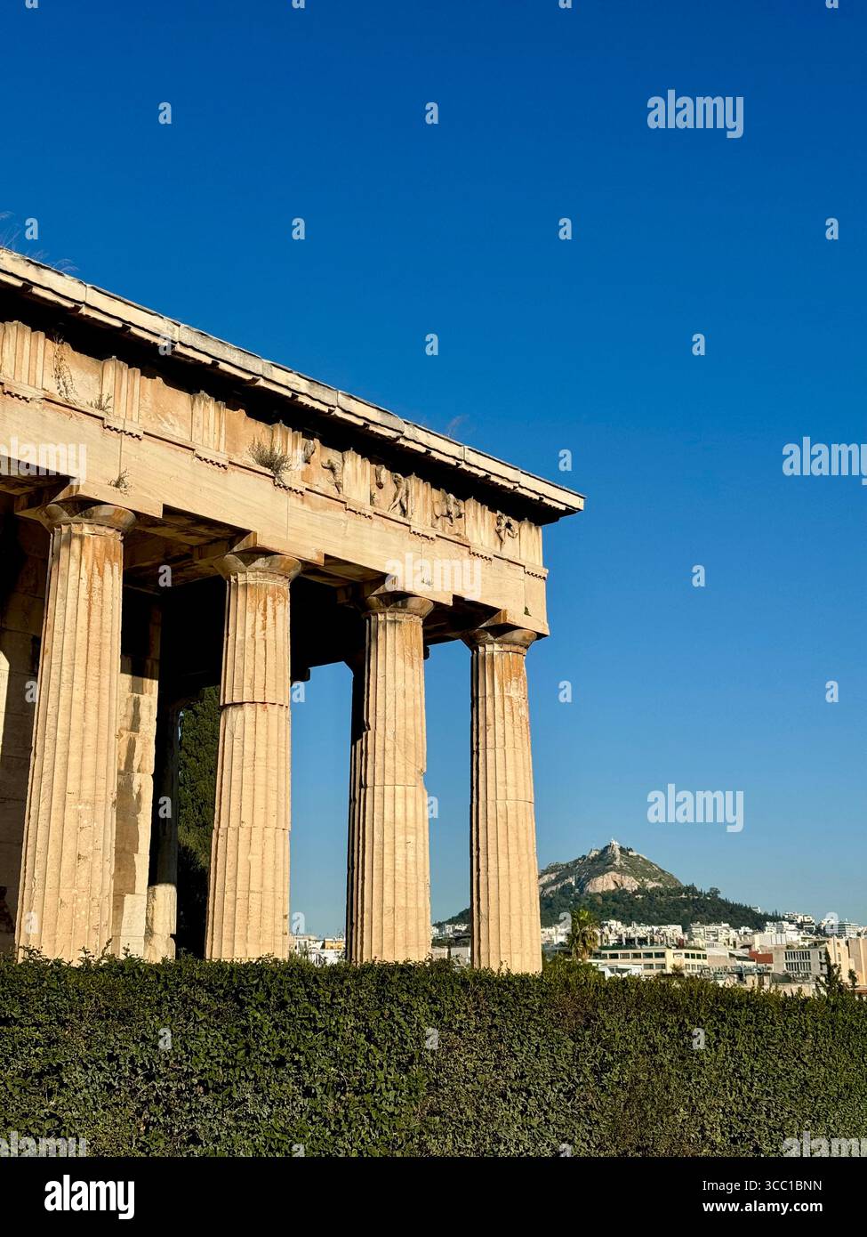 Viewpoint perspective of Temple of Hephaistos with Lycabettus Mountain in the background, Athens, Greece. - Smartphone Captured Stock Image