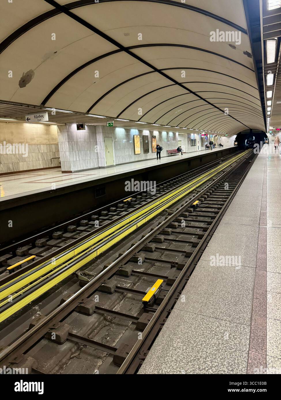 Modern metro station platform in Athens, Greece, with empty tracks and curved ceiling design. - Smartphone Captured Stock Image