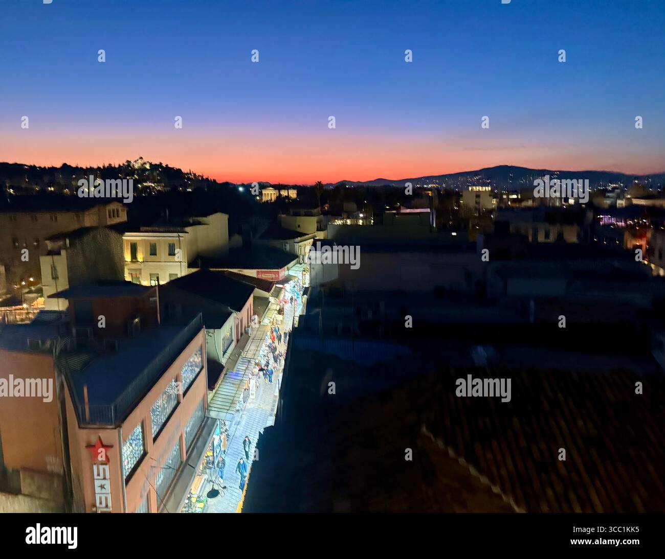 Sunset view over the rooftops of Athens, Greece, with a vibrant cityscape and glowing horizon. - Smartphone Captured Stock Image