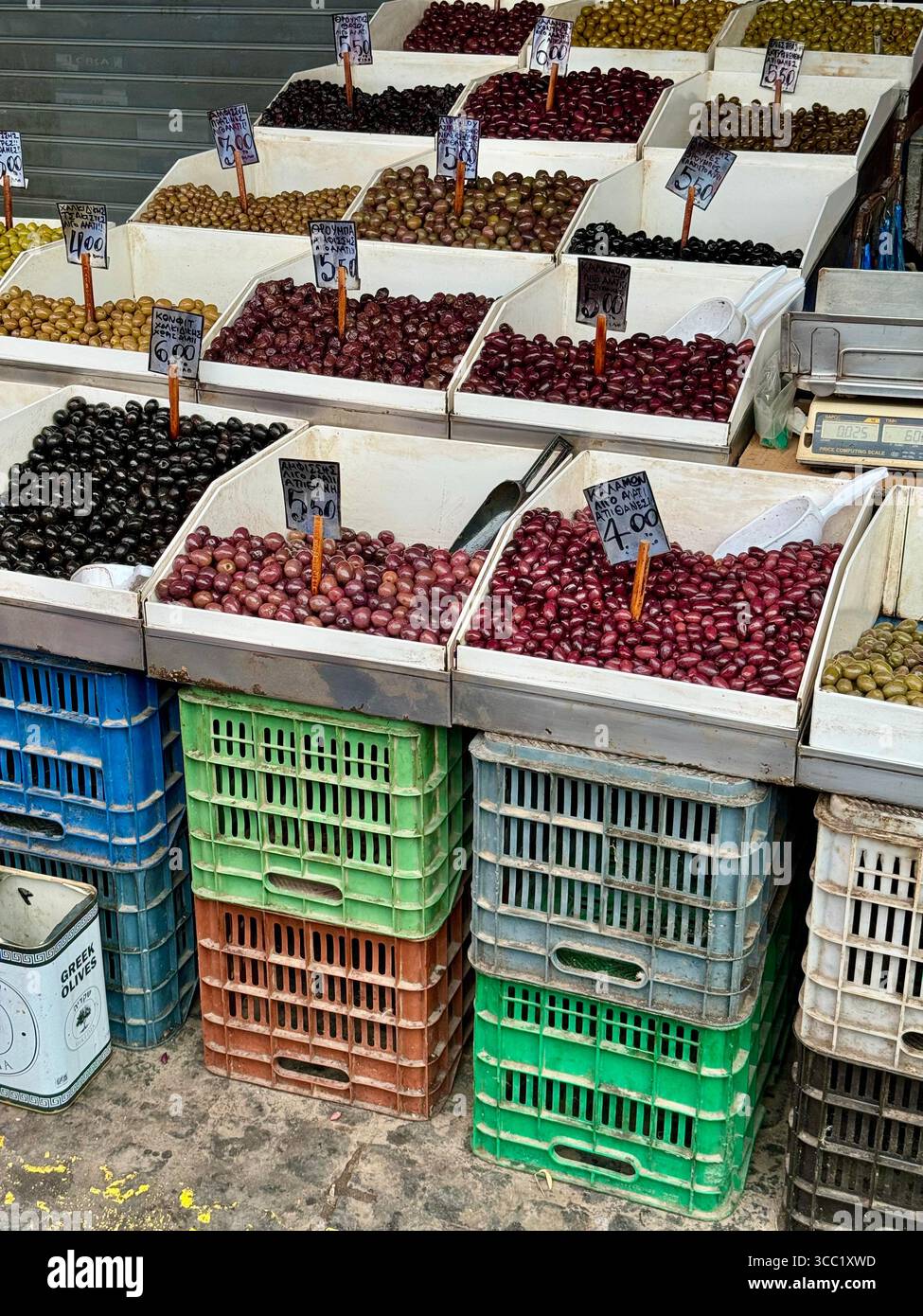 A colorful olive stand at a street market in Athens, Greece, showcasing a variety of local olives in crates. - Smartphone Captured Stock Image