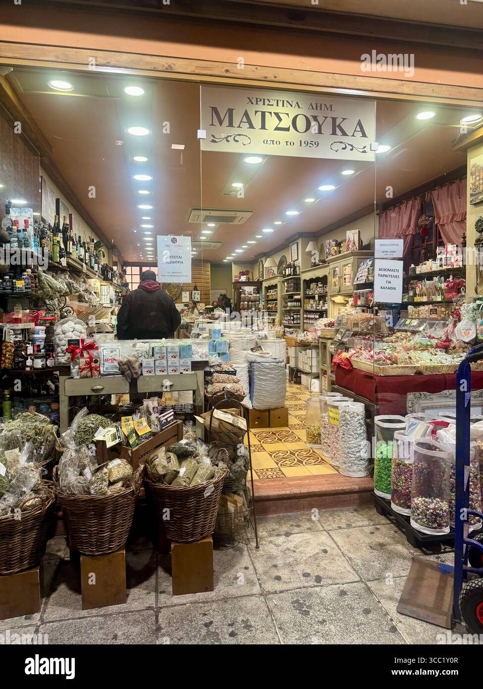 Traditional shop interior in downtown Athens filled with baskets, spices, sweets, and various goods. - Smartphone Captured Stock Image