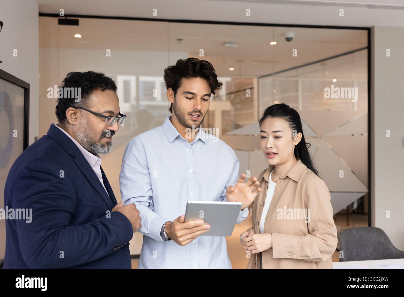 Diverse multiracial businesspeople group standing in office using tablet pc Stock Photo