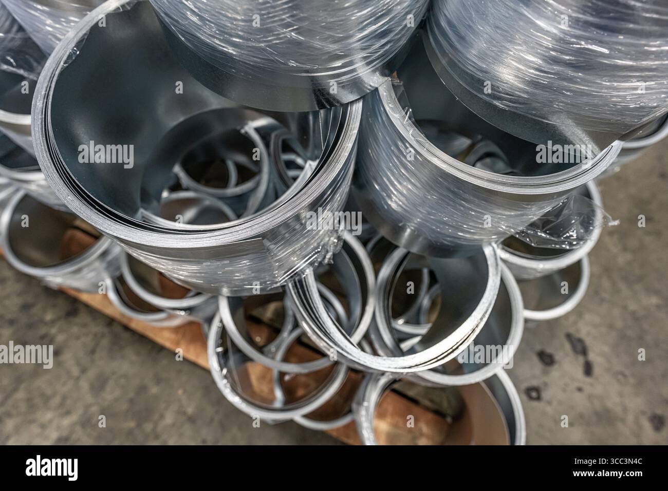 Stacks of rolled steel coils in metal factory Stock Photo - Alamy
