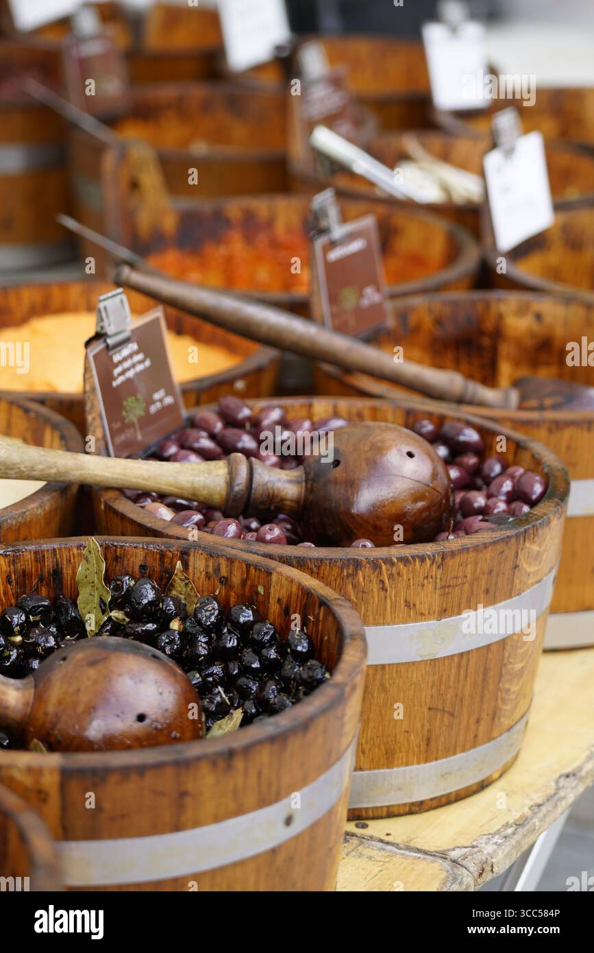 Assorted Olive Varieties Displayed in Rustic Wooden Barrels at Local Market Stall. Salisbury, England Stock Photo
