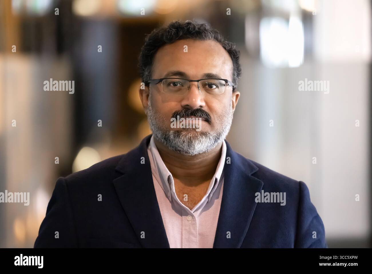 Serious elder Indian businessman looking at camera Stock Photo