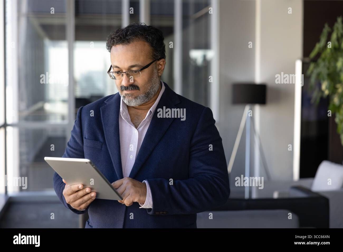 Serious Indian company director man using management application Stock Photo
