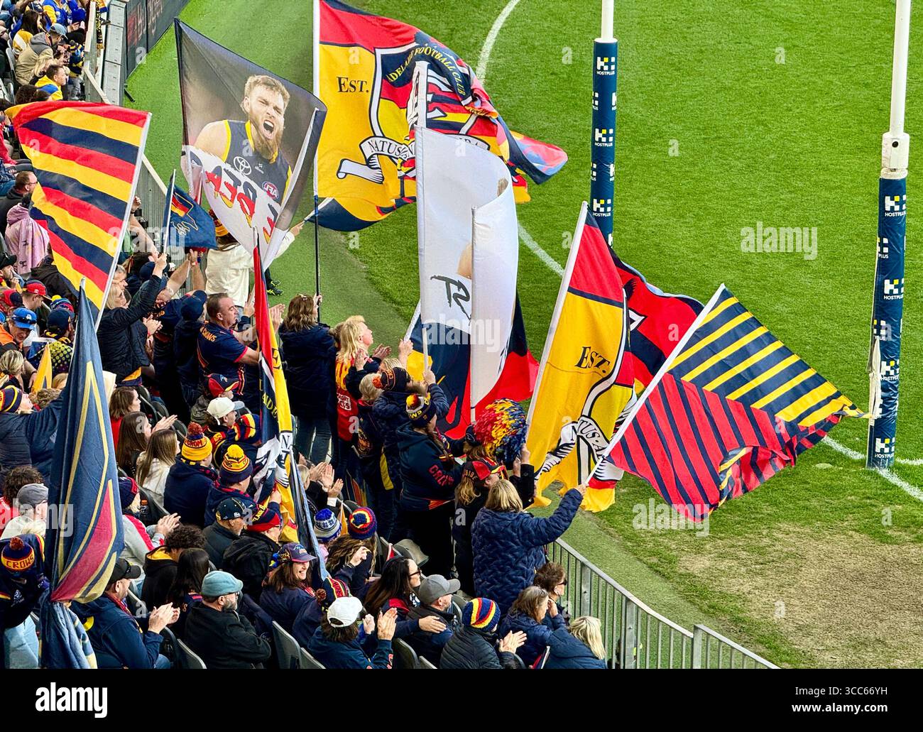 Adelaide Crows fans waving and cheering  their team as it scores a goal at AFL game at Optus Stadium in Perth Western Australia - Smartphone Captured Stock Image
