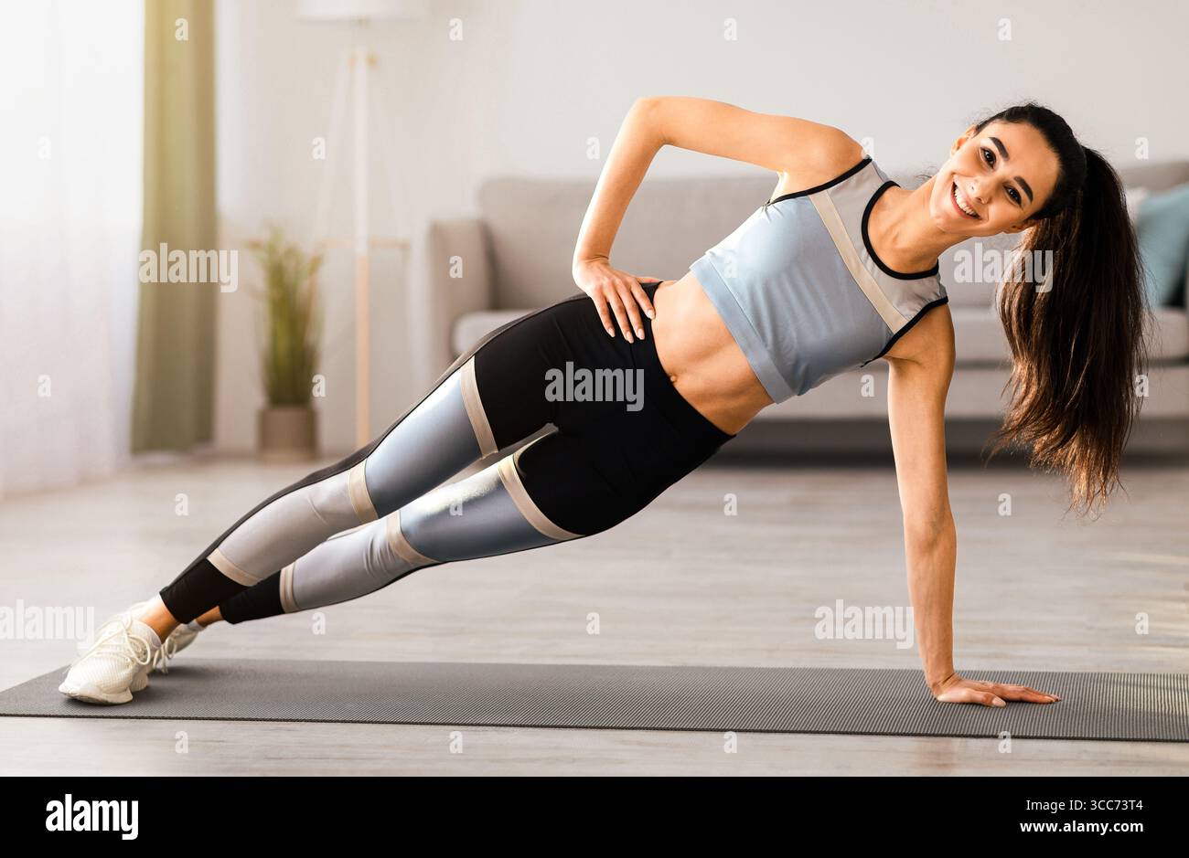 Sporty young woman training at home, planking Stock Photo - Alamy