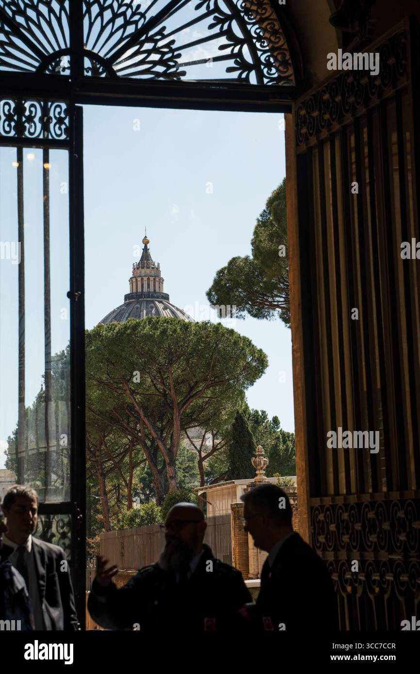 View of St. Peter's Basilica framed by a historic gate in Vatican City, Rome – a timeless glimpse into Italy’s cultural heart. Stock Photo