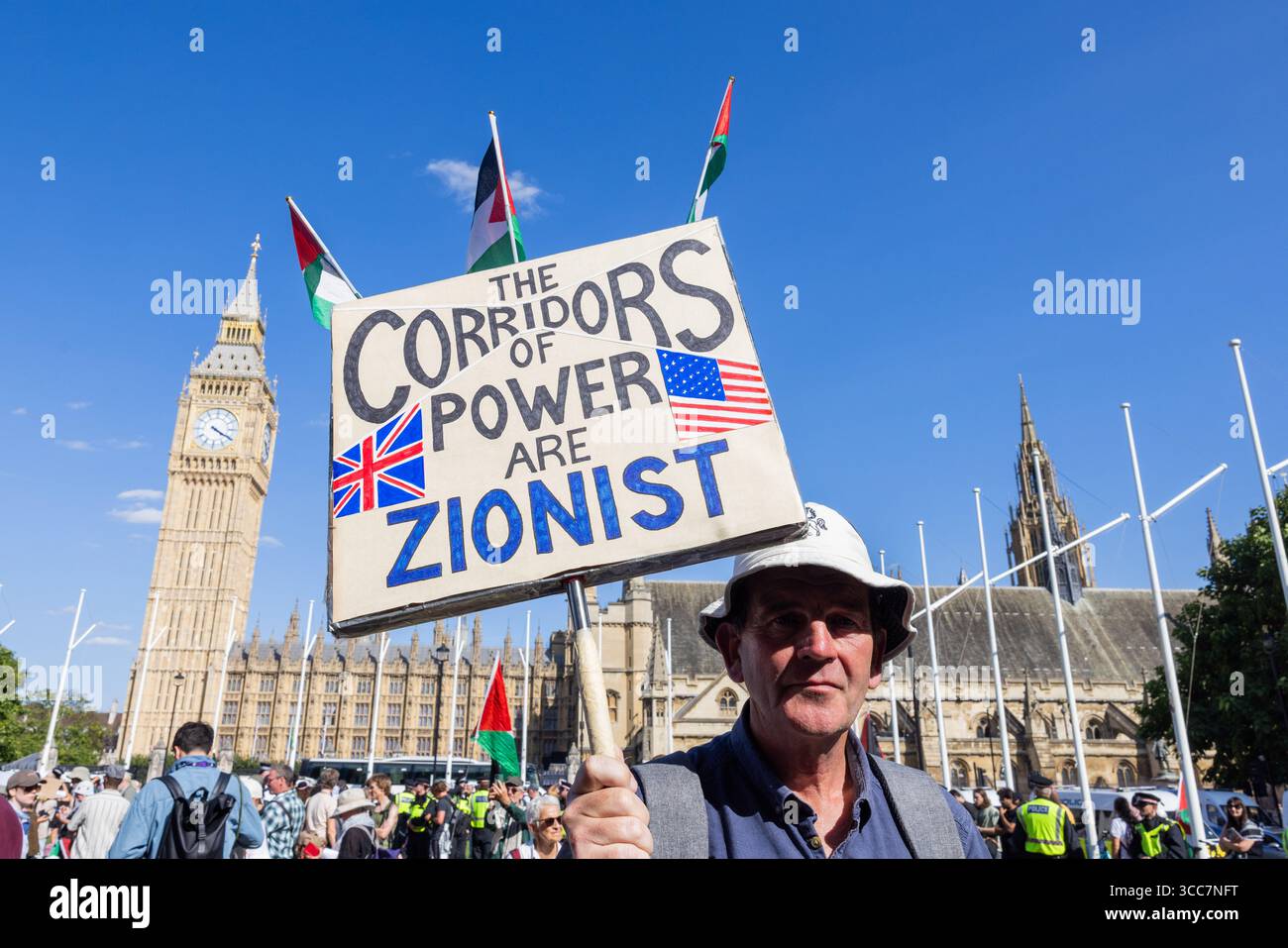 London, UK. 09 AUG, 2025. Person holds a sign stating 'The corridors of power are Zionist' in front of big ben as Police made 466 arrests for people showing support for newly proscribed terror group Palestine Action. The action, organised by Defend Our Juries, saw people arrested for holding placards that said 'I oppose Genocide, I suport Palestine Action' and took place in Parliament Square with an extremely heavy police presence. Credit Milo Chandler/Alamy Live News Stock Photo
