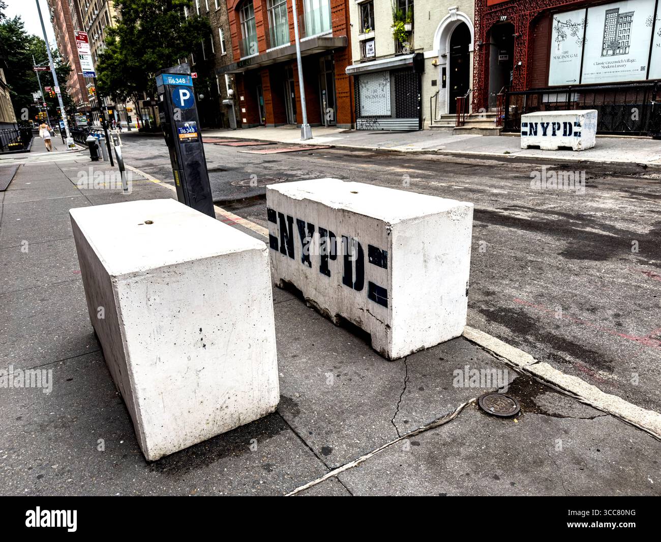 NYPD bollards on MacDougal Street serve as physical barriers to prevent unauthorized vehicle access and protect pedestrians and property - Smartphone Captured Stock Image
