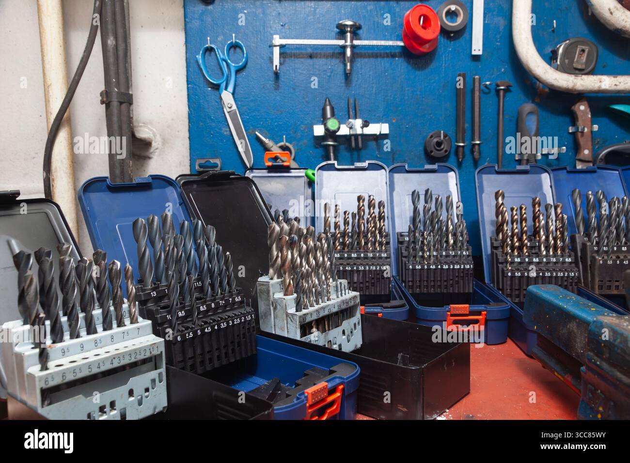 Sets of drills on a table in a workshop. Stock Photo