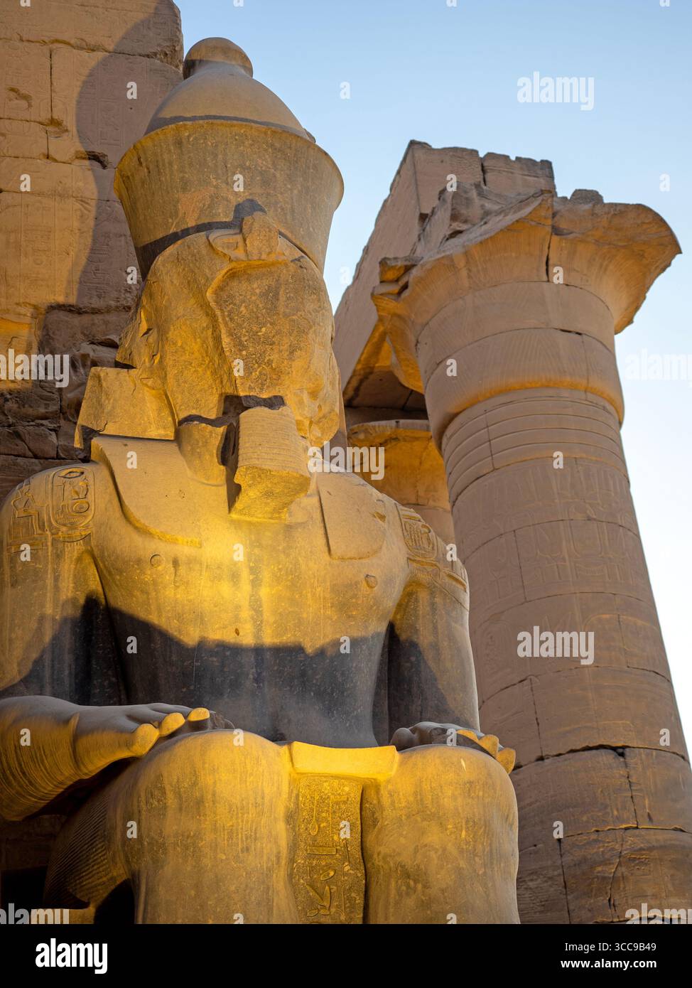 Faceless statue and a column of the Grand Colonnade at Luxor Temple Stock Photo