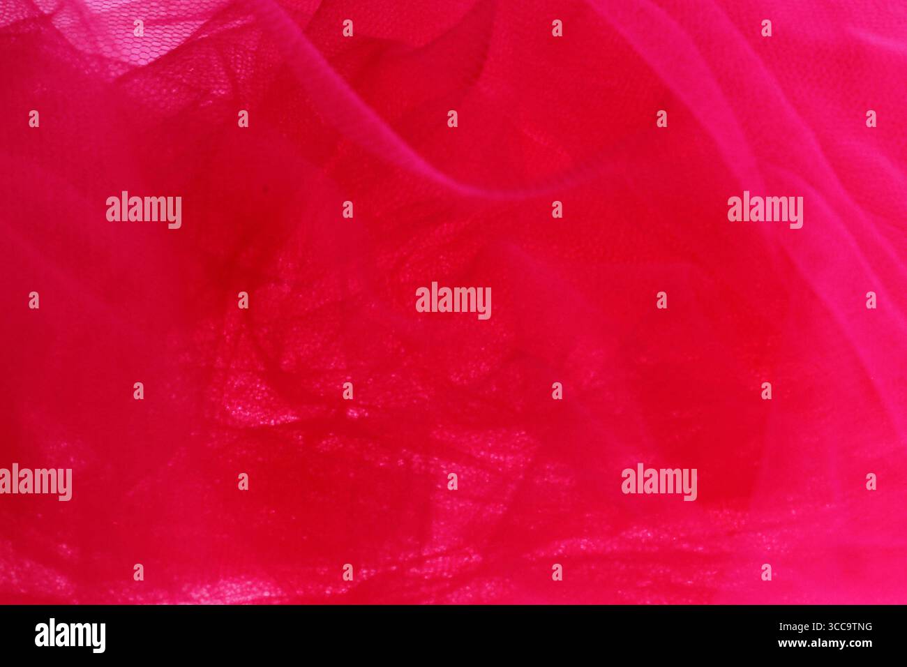 Red tulle fabric with a wavy and soft abstract lace pattern. Stock Photo