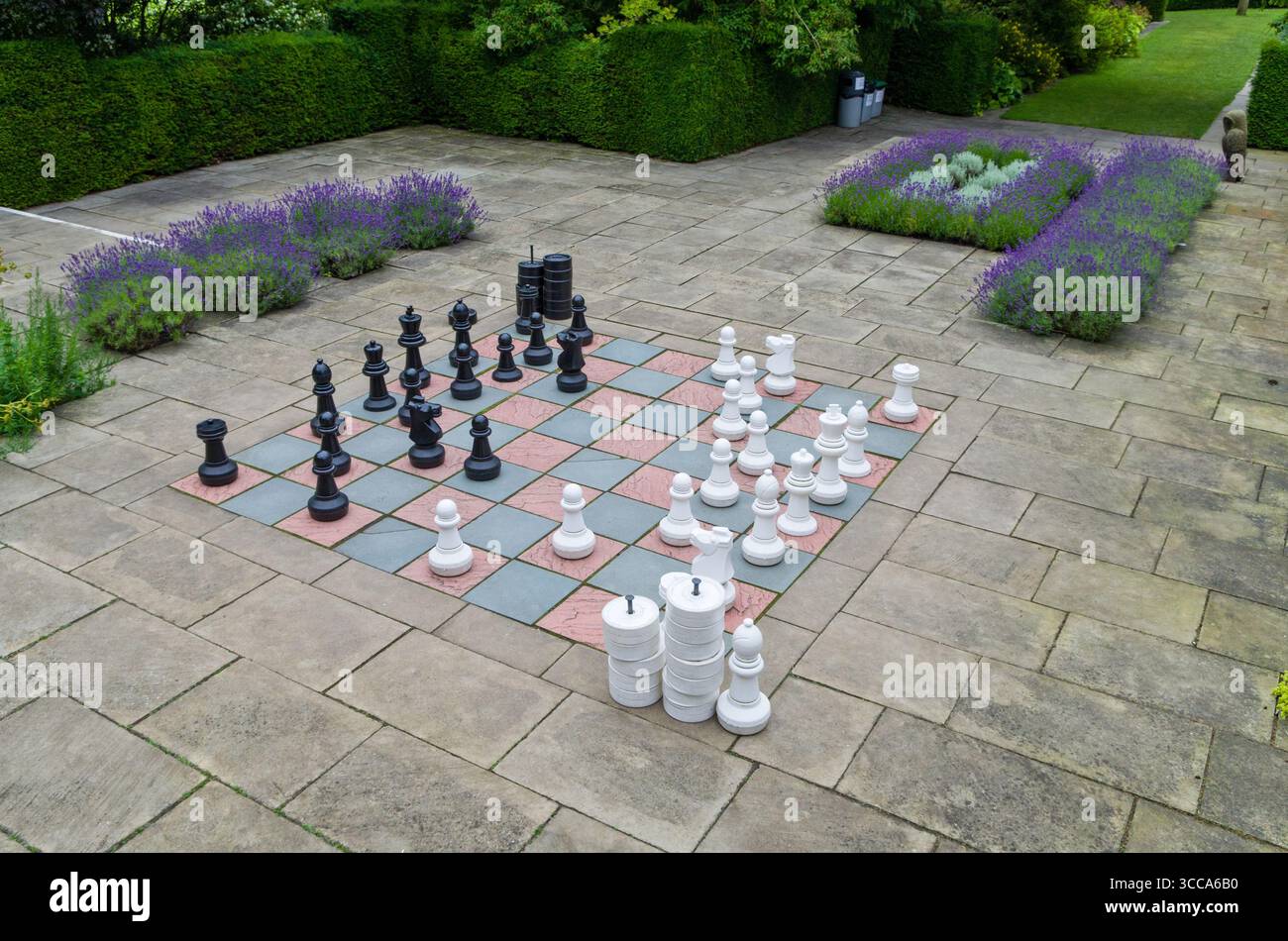 Large outdoor chess set in play at Falkland Palace, Scotland with giant pieces arranged on a garden board but no people visible Stock Photo