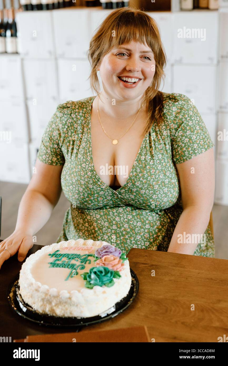 Smiling woman celebrates birthday with cake indoors Stock Photo