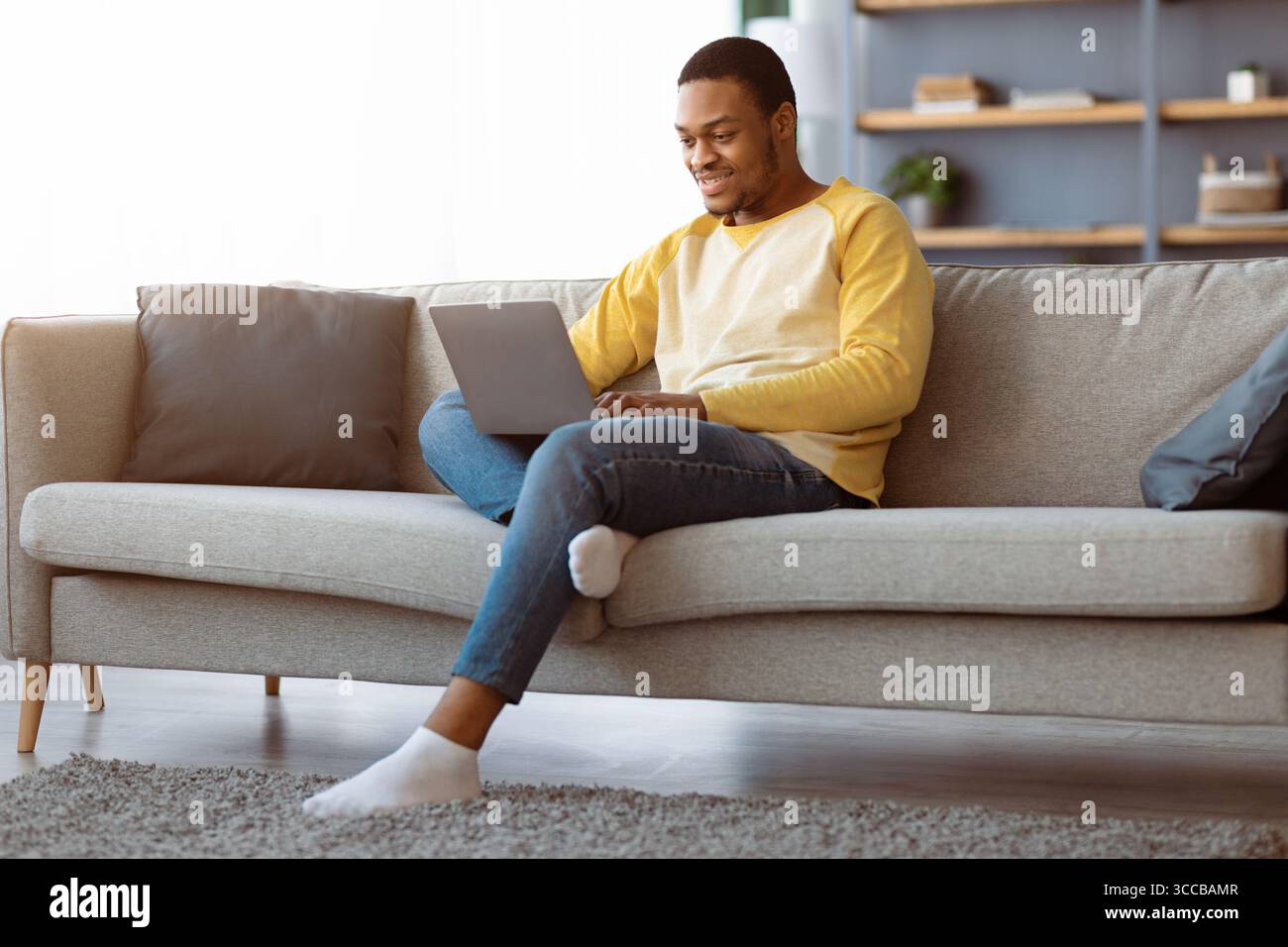 Black guy spending time at home, using laptop Stock Photo