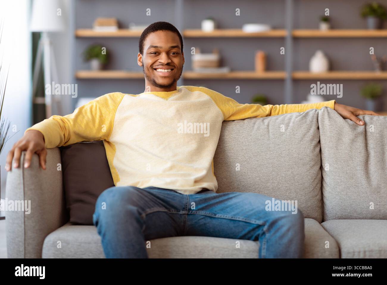 Relaxed african american man resting on sofa at home Stock Photo