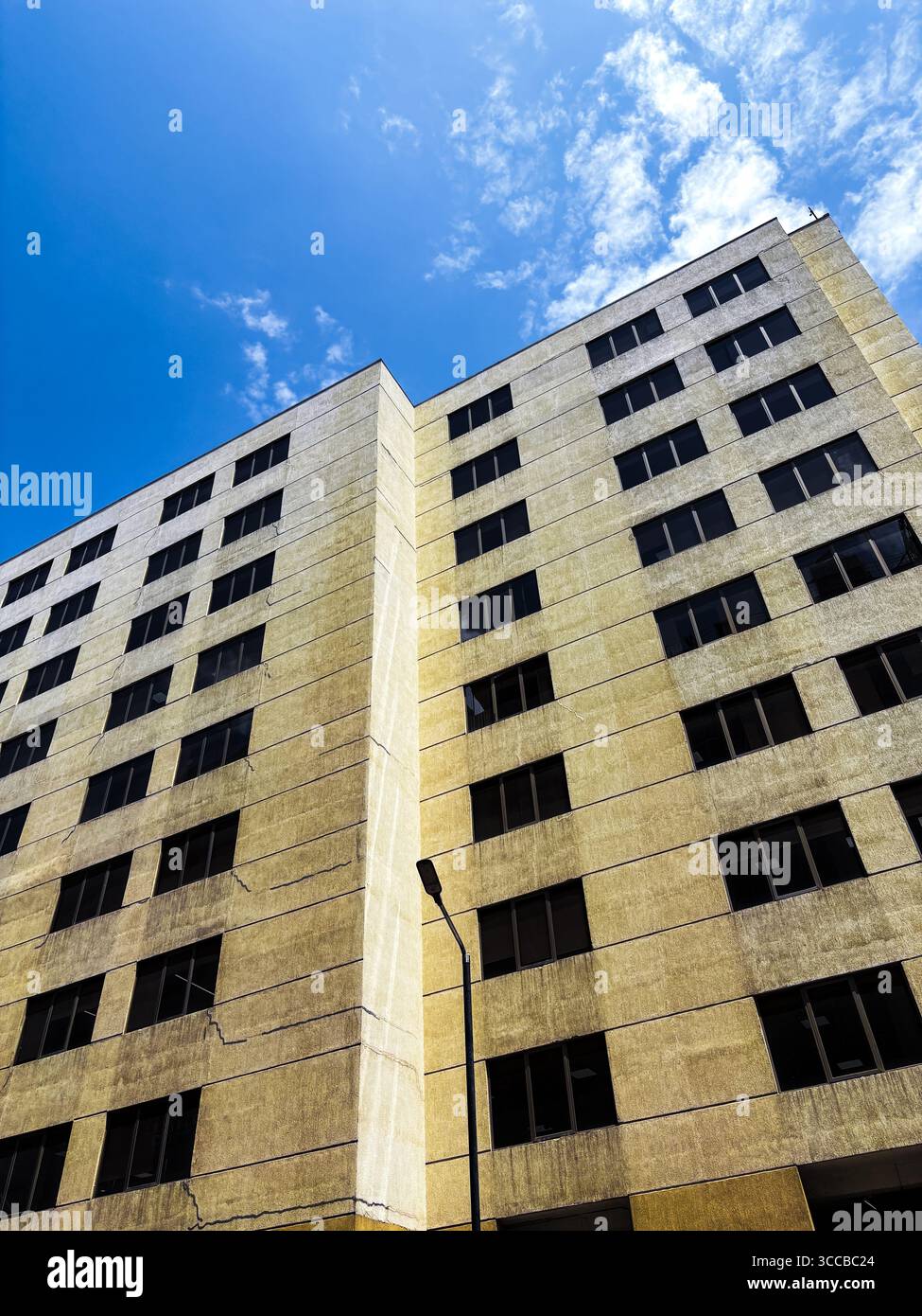 A modern corporate tower, a towering monument of steel and glass, triple-glazed windows that reflects the dynamic urban landscape inside a tech park. - Smartphone Captured Stock Image
