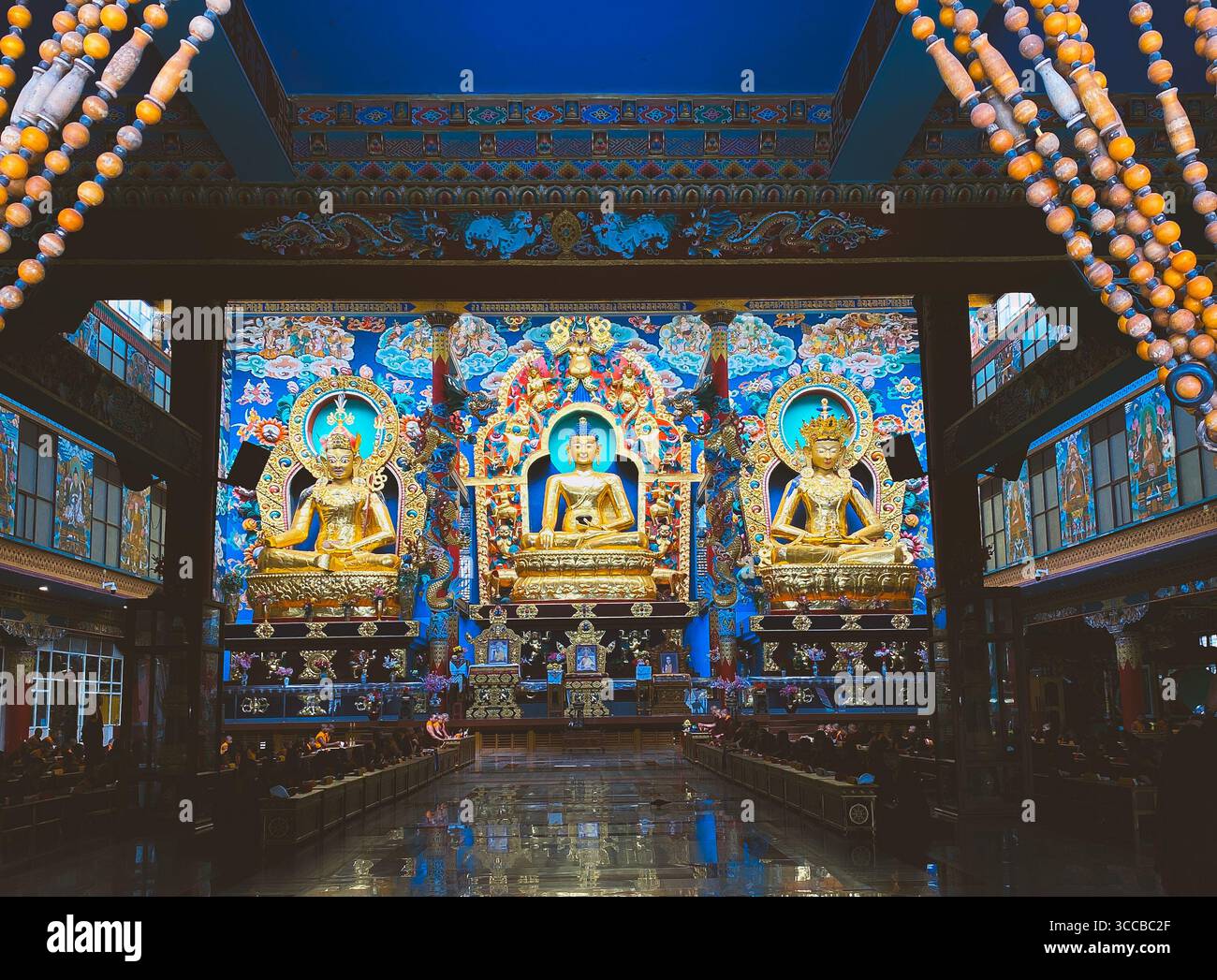 Peaceful monastery in India with three idols at the front with empty temple hall to exercise calm peaceful morning prayers and to practice mindfulness - Smartphone Captured Stock Image
