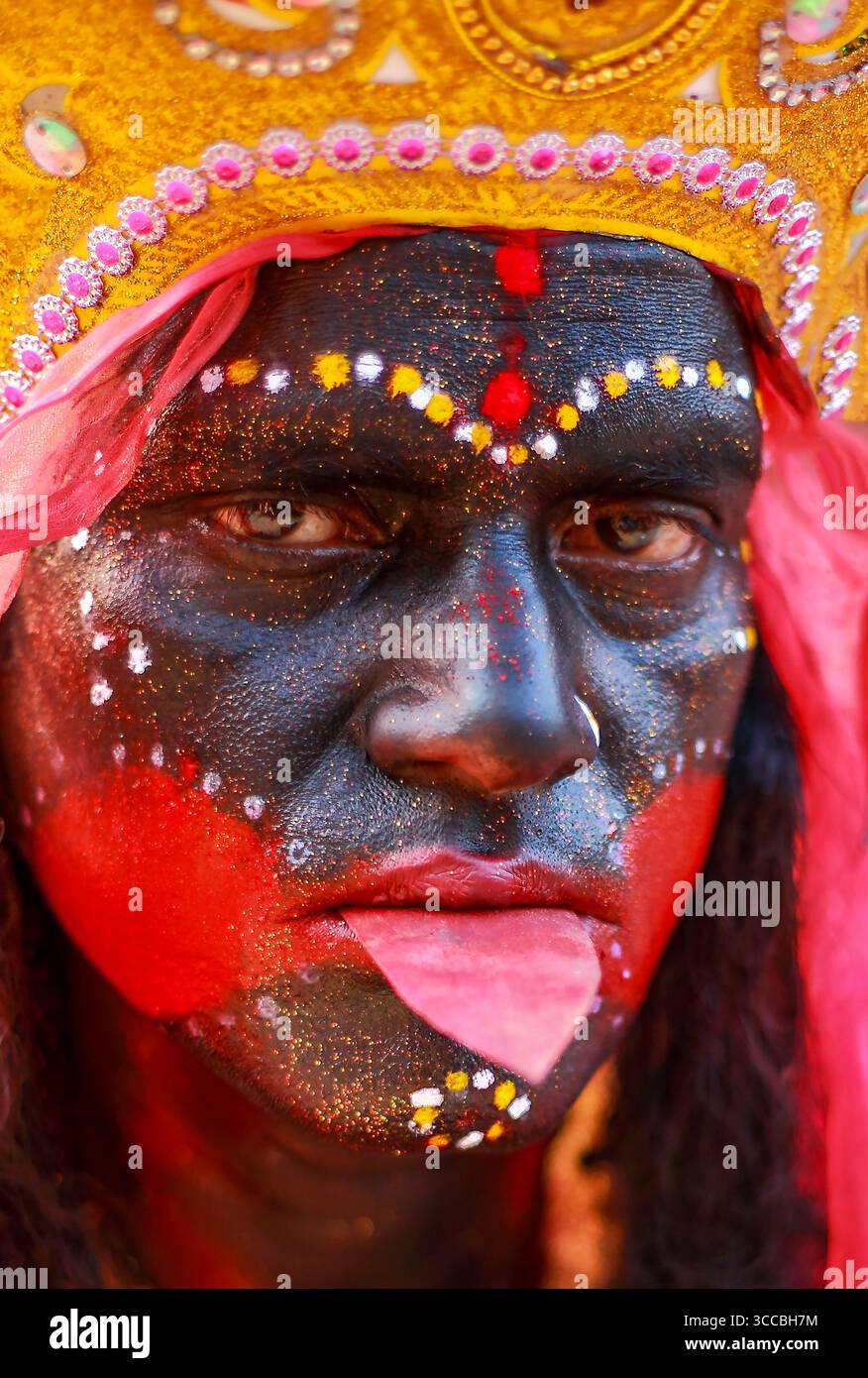 Chandanath hill, Bangladesh - 12 March 2021: View of a man's face painted black with bold red accents and ornate gold headwear, creating a striking contrast. Stock Photo