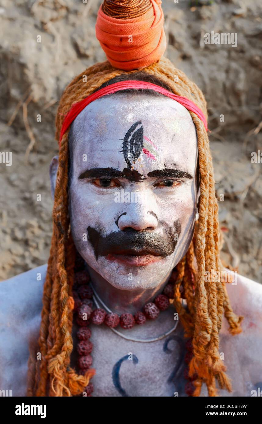 Chandanath hill, Bangladesh - 12 March 2021: View of a man with vibrant orange dreadlocks and striking white face paint, an intense gaze piercing through the contrasting colors. Stock Photo