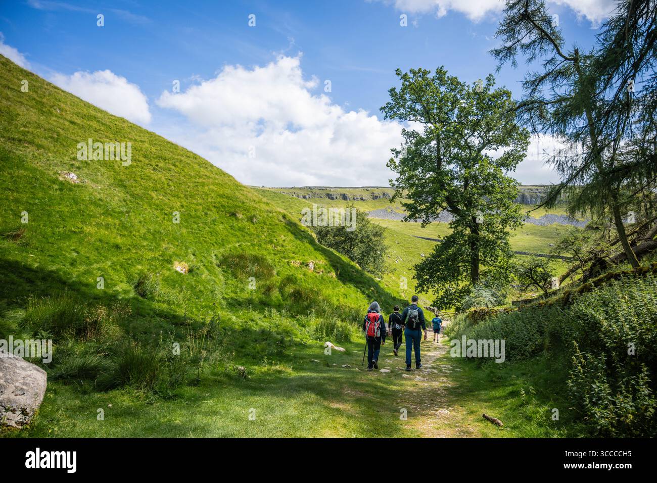 A family group descends Trow Gill after visiting Gaping Gill on the side of Ingleborough, Yorkshire Dales national park. Stock Photo