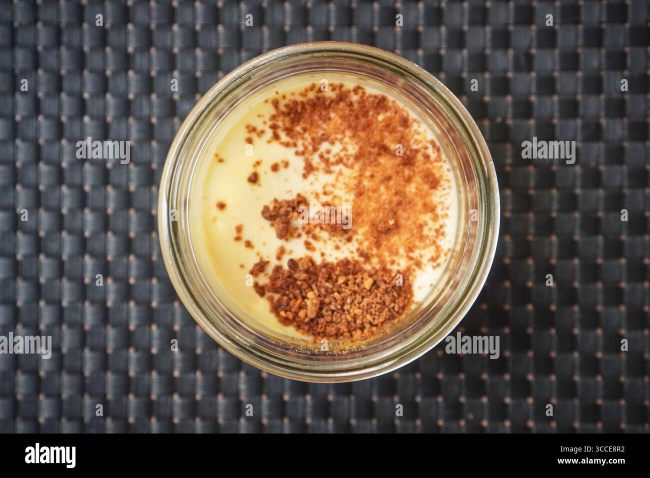 Single baked custard in a ramekin with caramelized surface, a classic dessert portion. Stock Photo