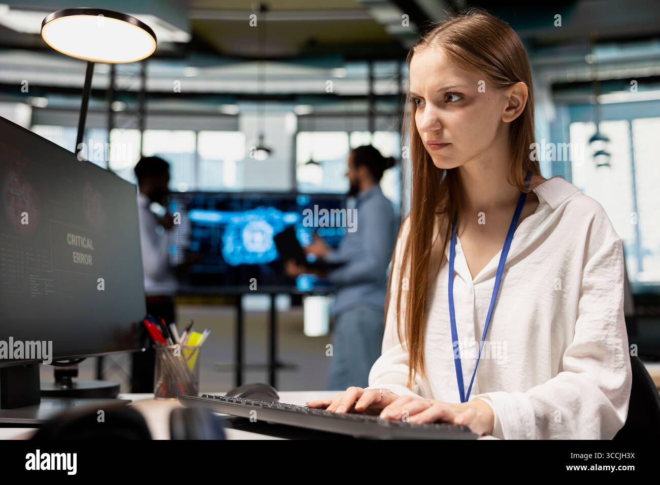 Anxious junior dev debugging code in office, looking for solutions to fix errors on PC display. Concerned system administrator reviewing error logs at computer, trying to to resolve critical glitches Stock Photo