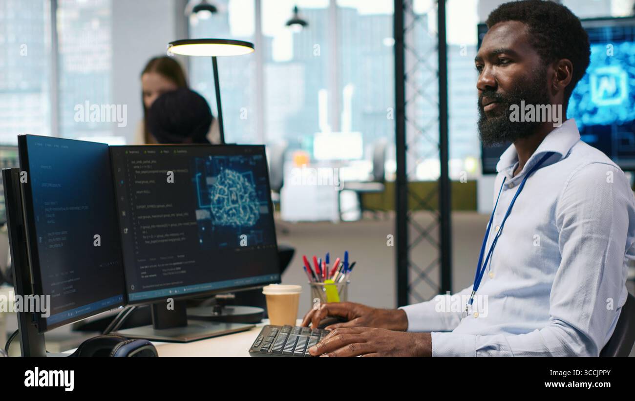 Computer scientist using AI on computer to optimize performance and forecast issues. African american worker in office training machine learning models using PC, camera A Stock Photo