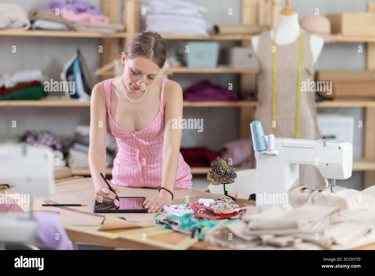 Woman dressmaker makes pattern using tablet Stock Photo