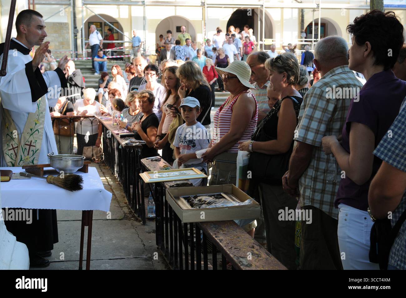 Communion Congregation People attending an outdoor Catholic mass, priest giving communion ...