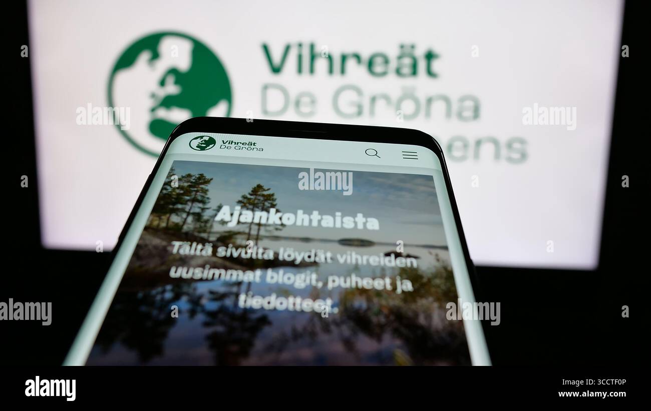 In this photo illustration, a mobile phone with the website of Finnish political party Vihrea Liitto (Vihreat) is seen on screen in front of logo. Stock Photo