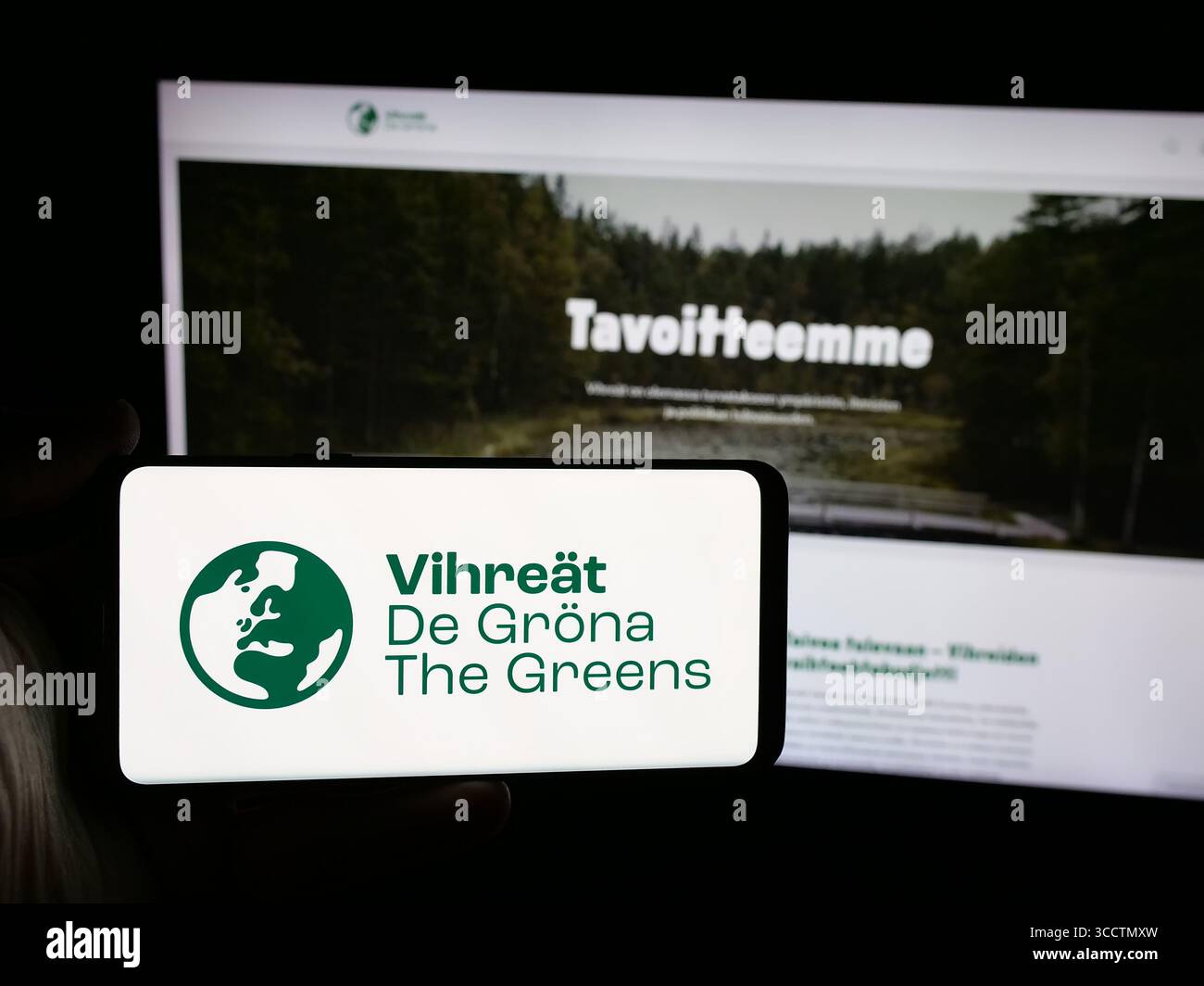 Germany. 25th July, 2025. In this photo illustration, a person is holding a smartphone with the logo of Finnish political party Vihrea Liitto (Vihreat) on screen in front of website. (Credit Image: © Timon Schneider/SOPA Images via ZUMA Press Wire) EDITORIAL USAGE ONLY! Not for Commercial USAGE! Stock Photo
