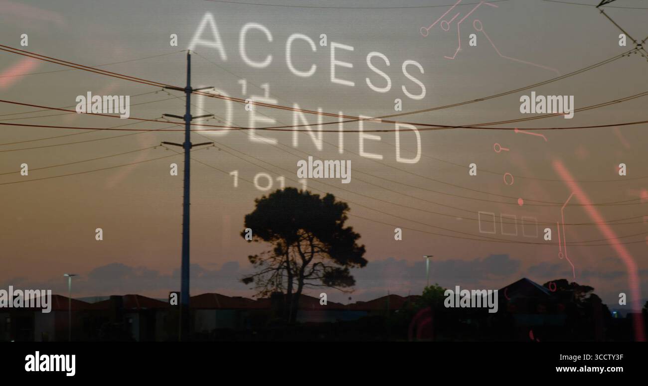 Displaying ACCESS DENIED and binary code over suburban dusk rooftops with pole wires and circuits Stock Photo