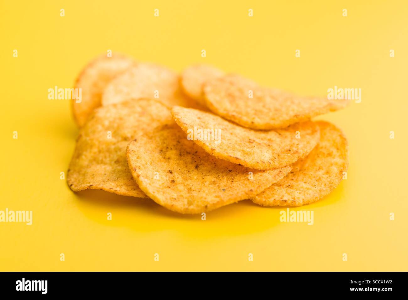 Crispy potato chips on an yellow background. Stock Photo
