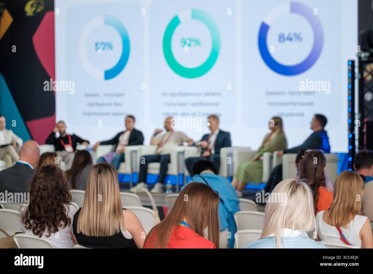 Attendees at conference watching panel discussion with analytical ...