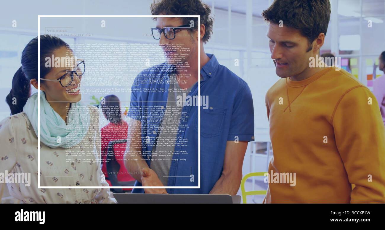 Reviewing laptop screen by three professionals in open-plan office, with digital code overlay Stock Photo