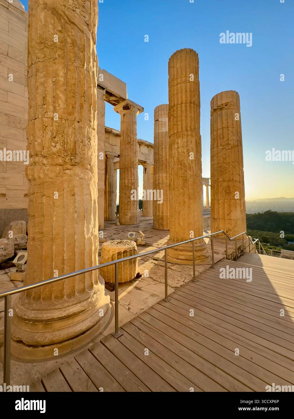 Golden hour sunset at the entrance of the Acropolis complex (Acrópole Propileia) in Athens, Greece, with tourists walking down the stairs. - Smartphone Captured Stock Image