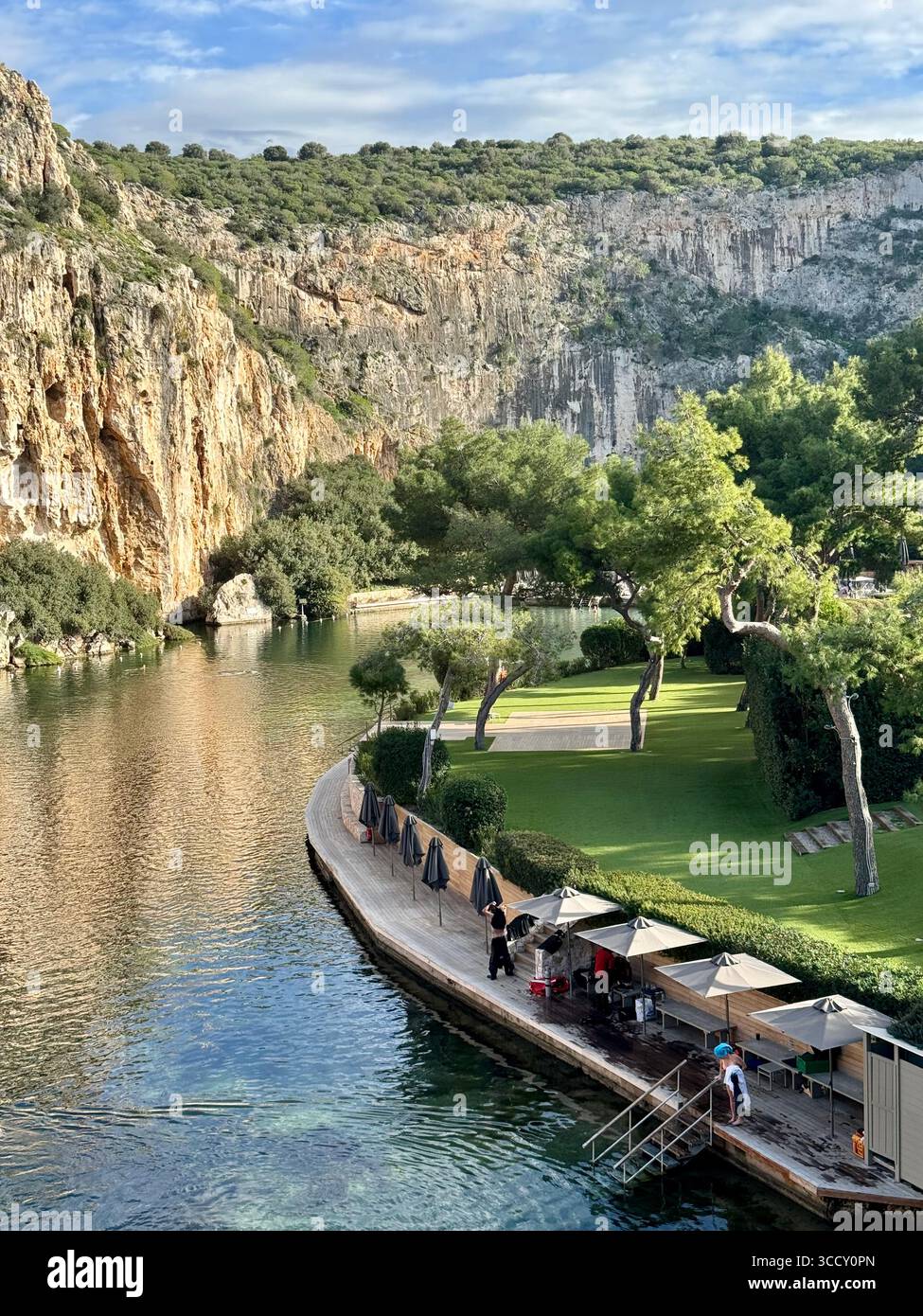Thermal Spa Lake Vouliagmeni, a natural geothermal lake surrounded by cliffs and lush greenery in Greece. - Smartphone Captured Stock Image