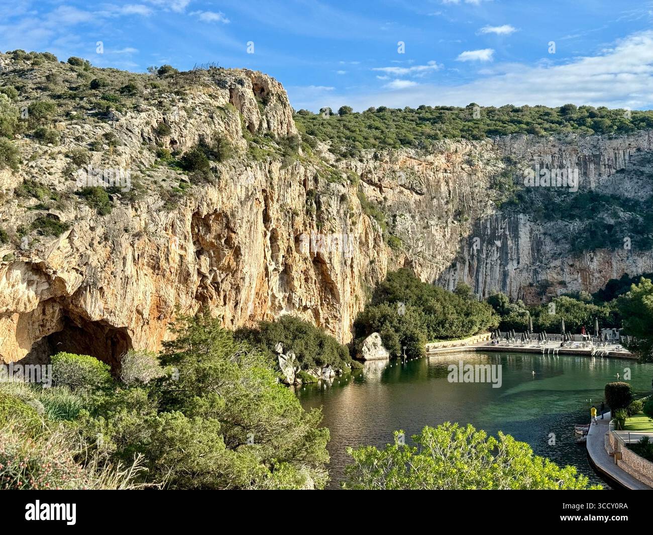 Thermal Spa Lake Vouliagmeni, a natural geothermal lake surrounded by cliffs and lush greenery in Greece. - Smartphone Captured Stock Image