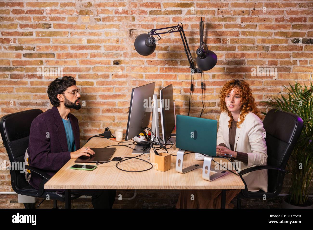 Two designers working on computers in modern office Stock Photo