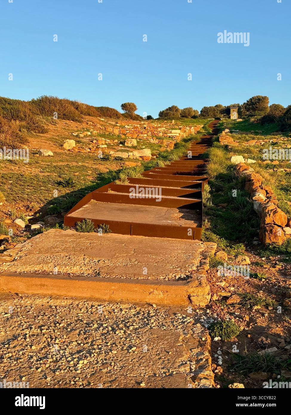 Golden hour light bathes the archaeological site of Sounion, Greece, including pathways and ruins near the Temple of Poseidon. - Smartphone Captured Stock Image