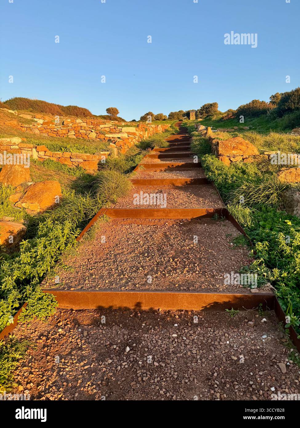 Golden hour light bathes the archaeological site of Sounion, Greece, including pathways and ruins near the Temple of Poseidon. - Smartphone Captured Stock Image