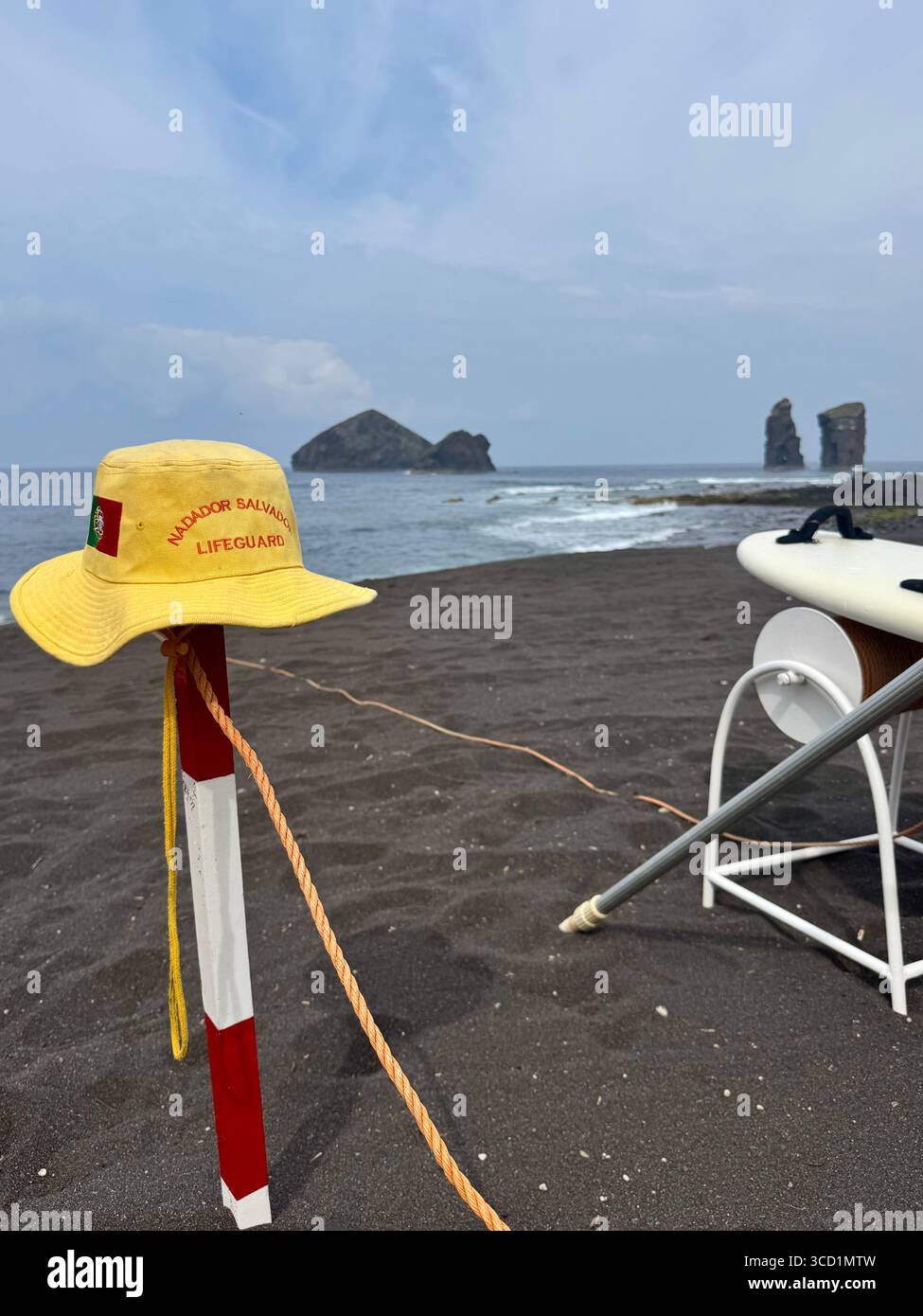 Lifeguard gear including yellow hat and chair on Mosteiros Beach, Azores. - Smartphone Captured Stock Image